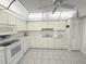 Well-lit kitchen features white cabinets, appliances, and a neutral tiled floor at 51 Fore Dr, New Smyrna Beach, FL 32168