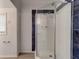 Bathroom featuring a shower stall with blue-tiled accents and white walls at 514 Mary Ave, New Smyrna Beach, FL 32168
