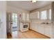Efficient kitchen area featuring white appliances, white cabinets, wood floors, and natural light at 514 Mary Ave, New Smyrna Beach, FL 32168