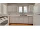 Well-lit kitchen featuring white appliances and cabinetry plus hardwood floors at 514 Mary Ave, New Smyrna Beach, FL 32168