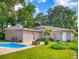 Spacious backyard with a small swimming pool, a fire pit, and a well-maintained lawn at 5476 W Bayshore Dr, Port Orange, FL 32127
