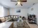 Bright living room featuring a comfortable gray sectional and stylish decor at 5476 W Bayshore Dr, Port Orange, FL 32127