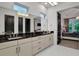 Bright bathroom with double sinks, black countertops, and ample storage in modern cabinetry at 6294 W Fallsgrove Ln, Port Orange, FL 32128