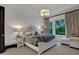 Bright bedroom featuring a tufted headboard, neutral colors, dark accent doors, and a window with backyard views at 6294 W Fallsgrove Ln, Port Orange, FL 32128