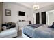 Bright bedroom with a cozy chair, stylish dresser, and dark doors offering access to bathroom and closet at 6294 W Fallsgrove Ln, Port Orange, FL 32128