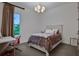 Bright bedroom features a cozy bed, a chandelier, and plenty of natural light from a window at 6294 W Fallsgrove Ln, Port Orange, FL 32128