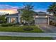 Inviting home featuring stone accents, a well-manicured lawn, and a spacious garage at 6294 W Fallsgrove Ln, Port Orange, FL 32128