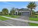 Home exterior showcasing lush landscaping, a spacious front yard, and a two-car garage at 6294 W Fallsgrove Ln, Port Orange, FL 32128