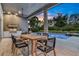 Covered patio area with grill, dining area, and a view of the pool and trees at 6294 W Fallsgrove Ln, Port Orange, FL 32128