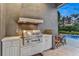 Outdoor kitchen featuring a built-in grill, sink, and countertop space for outdoor dining at 6294 W Fallsgrove Ln, Port Orange, FL 32128