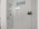 A luxurious shower featuring elegant marble-style tiling and frameless glass doors at 6294 W Fallsgrove Ln, Port Orange, FL 32128