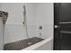 Modern shower featuring black honeycomb tiles, white subway tiling and brushed-nickel hardware at 6294 W Fallsgrove Ln, Port Orange, FL 32128