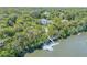 Expansive aerial view of a beautiful home surrounded by lush trees with private dock access to the water at 6325 Palmas Bay Cir, Port Orange, FL 32127