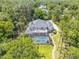 Aerial view showcasing a luxury home with a screened pool, lounging area, and beautiful green surroundings at 6325 Palmas Bay Cir, Port Orange, FL 32127