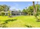 Expansive backyard featuring a screened pool, lush lawn, and mature trees at 6325 Palmas Bay Cir, Port Orange, FL 32127