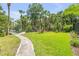This backyard features a beautiful green lawn with a brick path leading to the water at 6325 Palmas Bay Cir, Port Orange, FL 32127