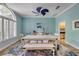 Dining room featuring a rustic wooden table, stylish chairs, and a unique blue ceiling fan at 6325 Palmas Bay Cir, Port Orange, FL 32127