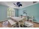 Light-filled dining area with a farmhouse-style table, bench seating, and views to the front yard at 6325 Palmas Bay Cir, Port Orange, FL 32127