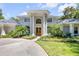 Grand exterior with a circular driveway, symmetrical columns, and a meticulously manicured front lawn at 6325 Palmas Bay Cir, Port Orange, FL 32127