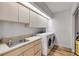 Efficient laundry room with washer, dryer, sink, and plenty of cabinet storage at 6325 Palmas Bay Cir, Port Orange, FL 32127