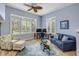 Bright living room with shuttered windows, a comfortable blue sofa, and stylish accent furniture at 6325 Palmas Bay Cir, Port Orange, FL 32127