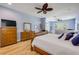 Light-filled bedroom with decorative ceiling fan, a fireplace, and warm wood-look flooring at 6325 Palmas Bay Cir, Port Orange, FL 32127