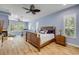 Serene bedroom with wood-look floors, plantation shutters, and a decorative ceiling fan at 6325 Palmas Bay Cir, Port Orange, FL 32127