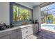 This is an outdoor bar featuring granite countertops with a view of the screened in pool at 6325 Palmas Bay Cir, Port Orange, FL 32127
