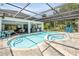 This fully enclosed in-ground pool and spa features an outdoor kitchen and entertainment area at 6325 Palmas Bay Cir, Port Orange, FL 32127