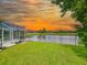 Backyard with a scenic pond view, lush lawn, and screened-in porch at 6804 Forkmead Ln, Port Orange, FL 32128