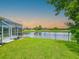 Backyard with a pond view, grassy lawn, and screened-in porch at 6804 Forkmead Ln, Port Orange, FL 32128