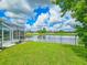 Scenic backyard view overlooking a tranquil pond with a screened lanai at 6804 Forkmead Ln, Port Orange, FL 32128