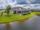 Backyard view highlighting the screened-in lanai and the tranquil pond at 6804 Forkmead Ln, Port Orange, FL 32128