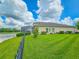 Backyard view featuring lush green lawn and a screened lanai overlooking the tranquil pond at 6804 Forkmead Ln, Port Orange, FL 32128