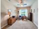 Bright bedroom with a ceiling fan, large window, and classic desk setup for a productive workspace at 6804 Forkmead Ln, Port Orange, FL 32128