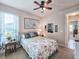 Inviting bedroom with a floral quilt, ceiling fan, and views to another room at 6804 Forkmead Ln, Port Orange, FL 32128