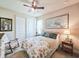 Comfortable bedroom with floral bedding, a ceiling fan, and a window with natural light at 6804 Forkmead Ln, Port Orange, FL 32128