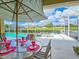 Outdoor dining area on the lanai with views of the pool and lush greenery at 6804 Forkmead Ln, Port Orange, FL 32128