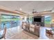 Open living room with tile flooring, sliding glass doors to the outdoor pool area, and tray ceiling at 6804 Forkmead Ln, Port Orange, FL 32128