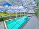 Screened pool area with a long, sparkling pool and a serene view of the property at 6804 Forkmead Ln, Port Orange, FL 32128