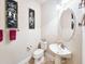 Stylish powder room featuring decorative art, a pedestal sink, and ceramic tile flooring at 6804 Forkmead Ln, Port Orange, FL 32128