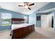 Well-lit bedroom with a ceiling fan, closet, and large window with a view at 684 Rochester Ct, New Smyrna Beach, FL 32168