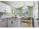Cozy breakfast nook boasts white cabinets, a dining table, and backyard views through the windows at 684 Rochester Ct, New Smyrna Beach, FL 32168