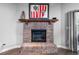 Close up of the brick fireplace with a dark wood mantle and decorative art at 684 Rochester Ct, New Smyrna Beach, FL 32168