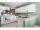 Well-maintained kitchen featuring white cabinets, stainless steel microwave, and green accent walls at 684 Rochester Ct, New Smyrna Beach, FL 32168
