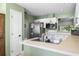Kitchen with stainless steel fridge, white cabinets, and view to screened lanai at 684 Rochester Ct, New Smyrna Beach, FL 32168