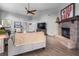 Spacious living room with brick fireplace, wood floors, and comfortable seating at 684 Rochester Ct, New Smyrna Beach, FL 32168