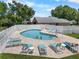 Community pool area, featuring lounge chairs, a pool, and a white picket fence at 684 Rochester Ct, New Smyrna Beach, FL 32168