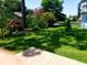 Lush backyard featuring mature trees, flowering plants, and a tranquil water view at 714 Fox Tail Ct, New Smyrna Beach, FL 32168