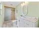 Bright bathroom featuring a marble countertop, white vanity, and walk-in shower with glass door at 800 Black Duck Dr, Port Orange, FL 32127
